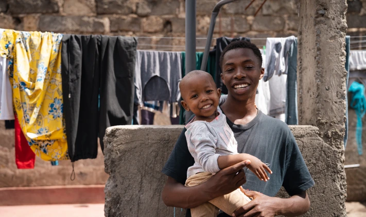 child being held by someone while outside