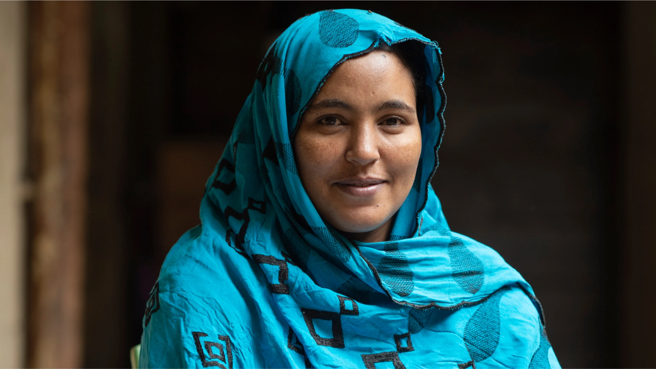 woman in blue garb smiling