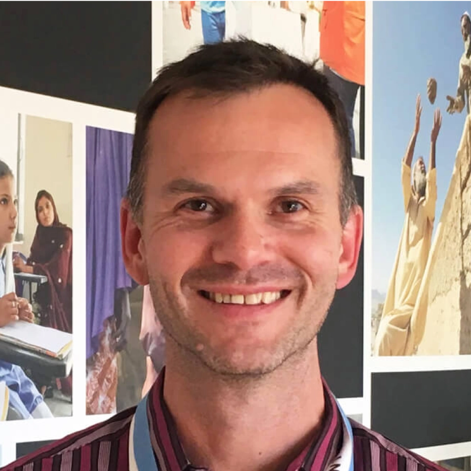 man smiling in front of pictures