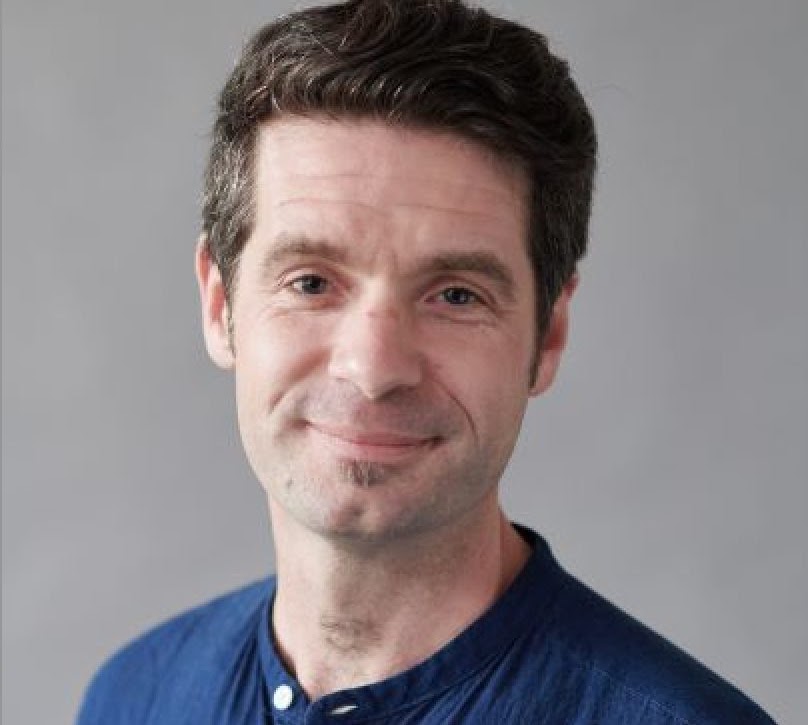 man in a blue shirt smiling