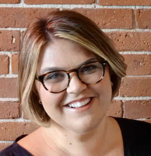 woman with glasses smiling