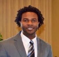 man in a grey suit with tie smiling
